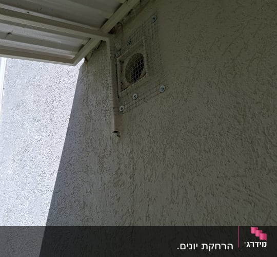רשת מונעת כניסת יונים על פתח אוורור בקיר חיצוני